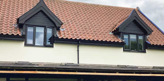 Black uPVC dormer cladding and Black Grain-on-Golden Oak windows fitted in Thorndon